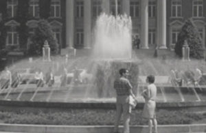 Historic image of two people in front of a fountain